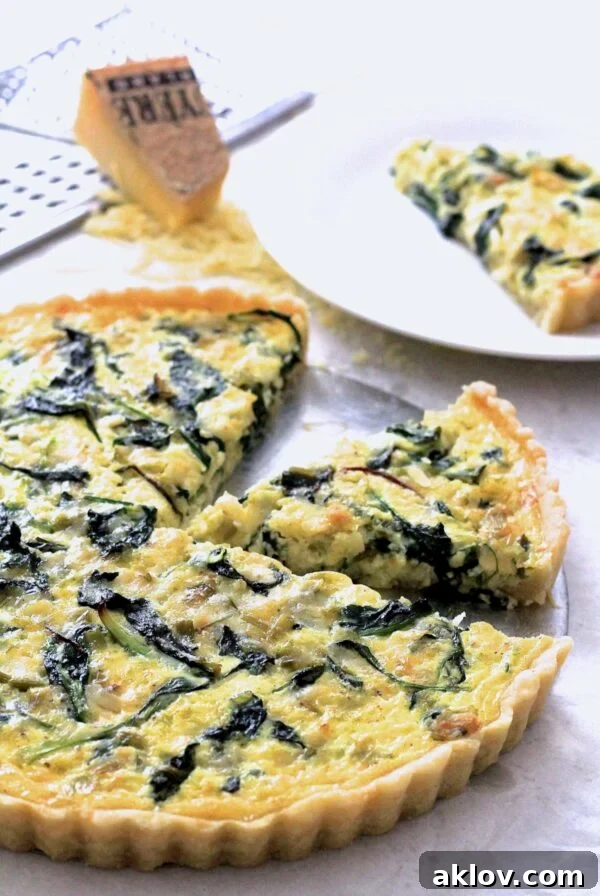 Rustic Greens, Leek and Gruyere Tart with two wedges cut out.