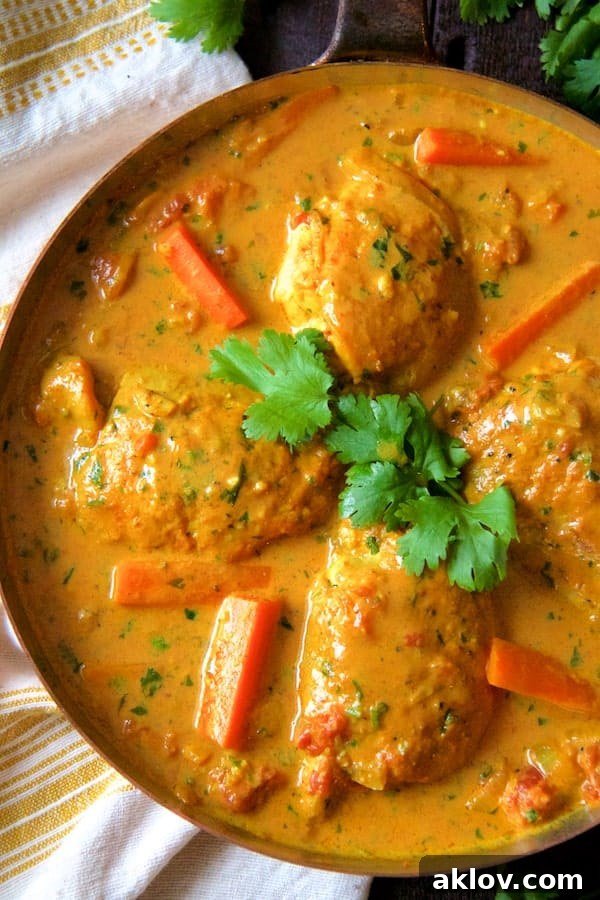 Fragrant Curry Braised Chicken Thighs 4 Photo of Curry Braised Chicken Thighs in skillet with carrots garnished with cilantro sprigs. Served with rice, a perfect meal.