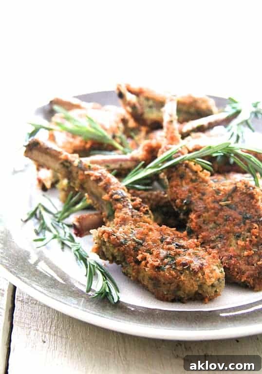 Photo of Parmesan and Herb-Crusted Lamb Chops on platter garnished with rosemary.