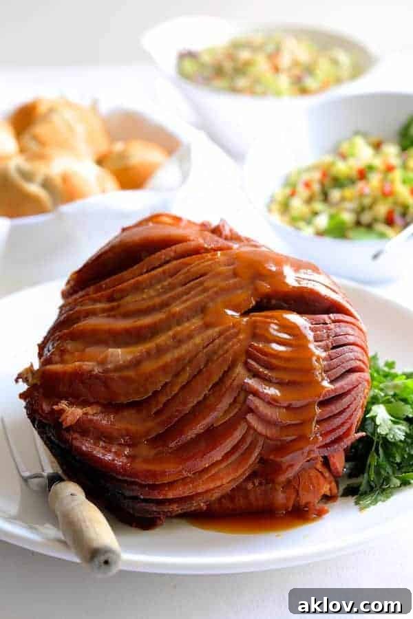 Photo of Slow Cooker Honey Ham with Pineapple Salsa on white platter with sauce drizzled down the front.