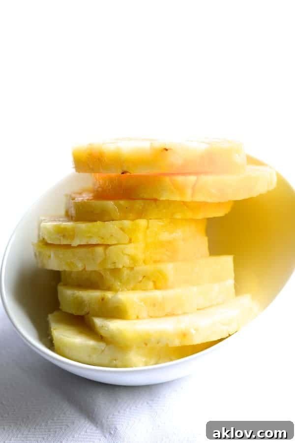 Photo of pineapple slices in white bowl.