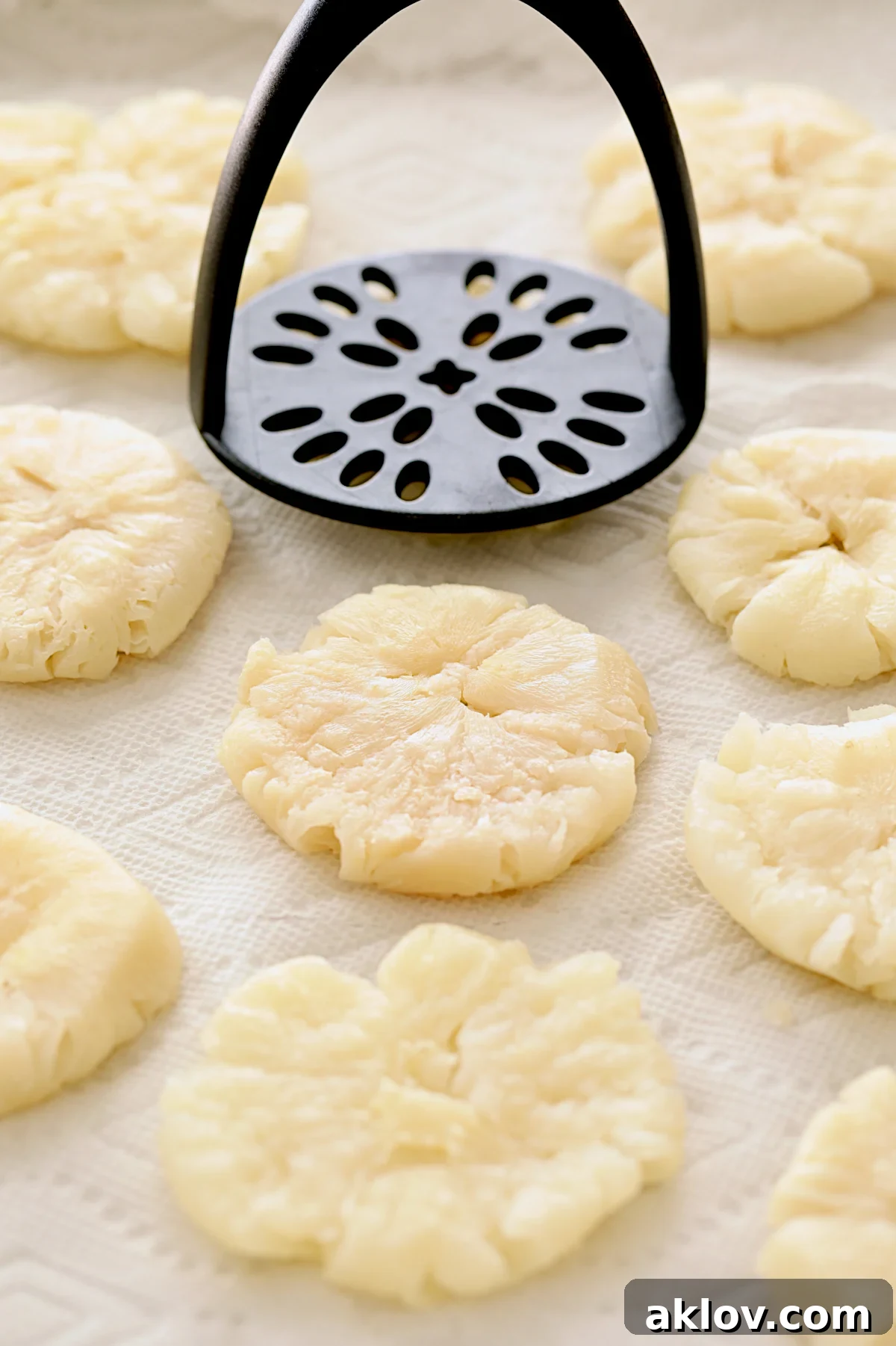 A visual guide showing cooked turnips neatly arranged on paper towels, being expertly smashed using a potato masher to achieve uniform thickness.