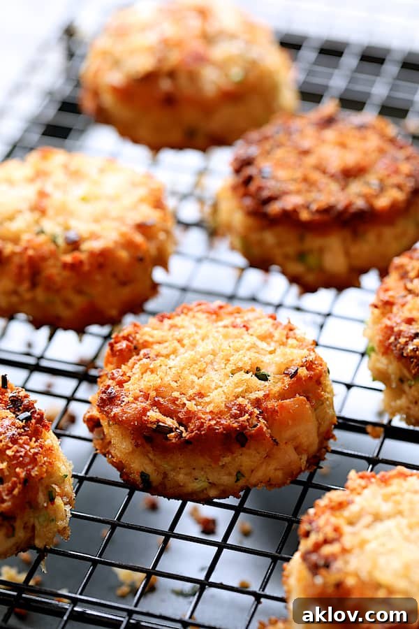 Freshly fried Tuna Kimchi Cakes resting on a wire cooling rack, allowing excess oil to drain and maintain their crispy texture.