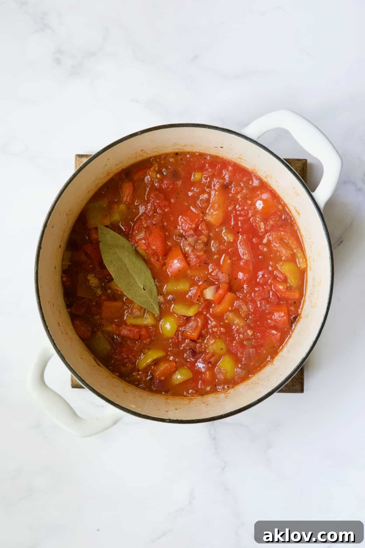 Tomato sauce added to Dutch oven with peppers.