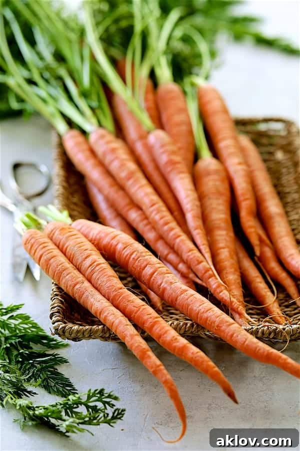 A wicker basket filled with fresh, vibrant carrots, some with their green tops still attached.