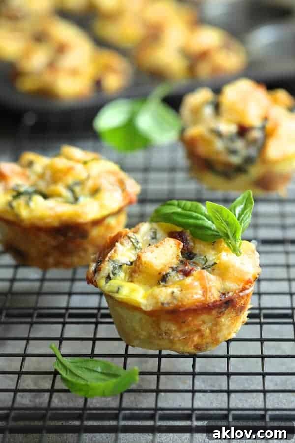 Photo of Muffin Pan Stratas with Basil and Sun-Dried Tomatoes on a cooling rack, elegantly garnished with fresh basil leaves.