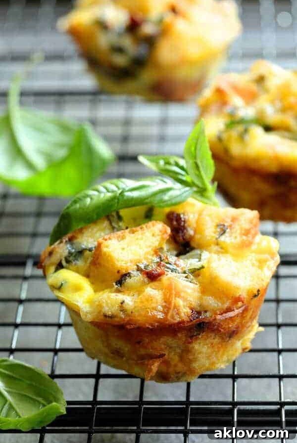 Muffin Pan Stratas with Basil and Sun Dried Tomatoes close-up on cooling rack garnished with fresh basil.