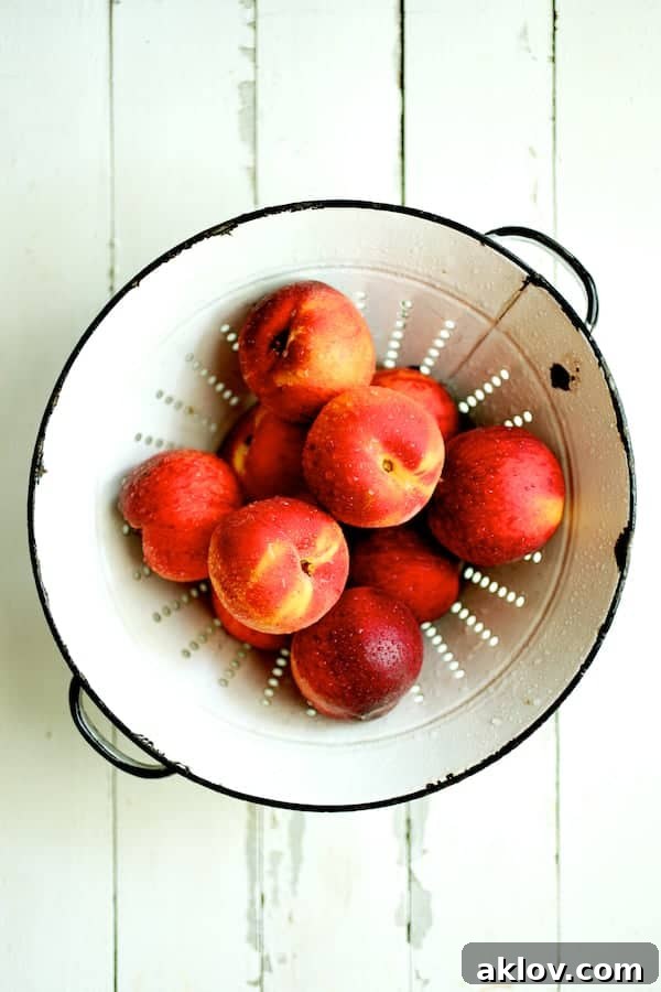 Photo of freshly washed peaches in white colander.