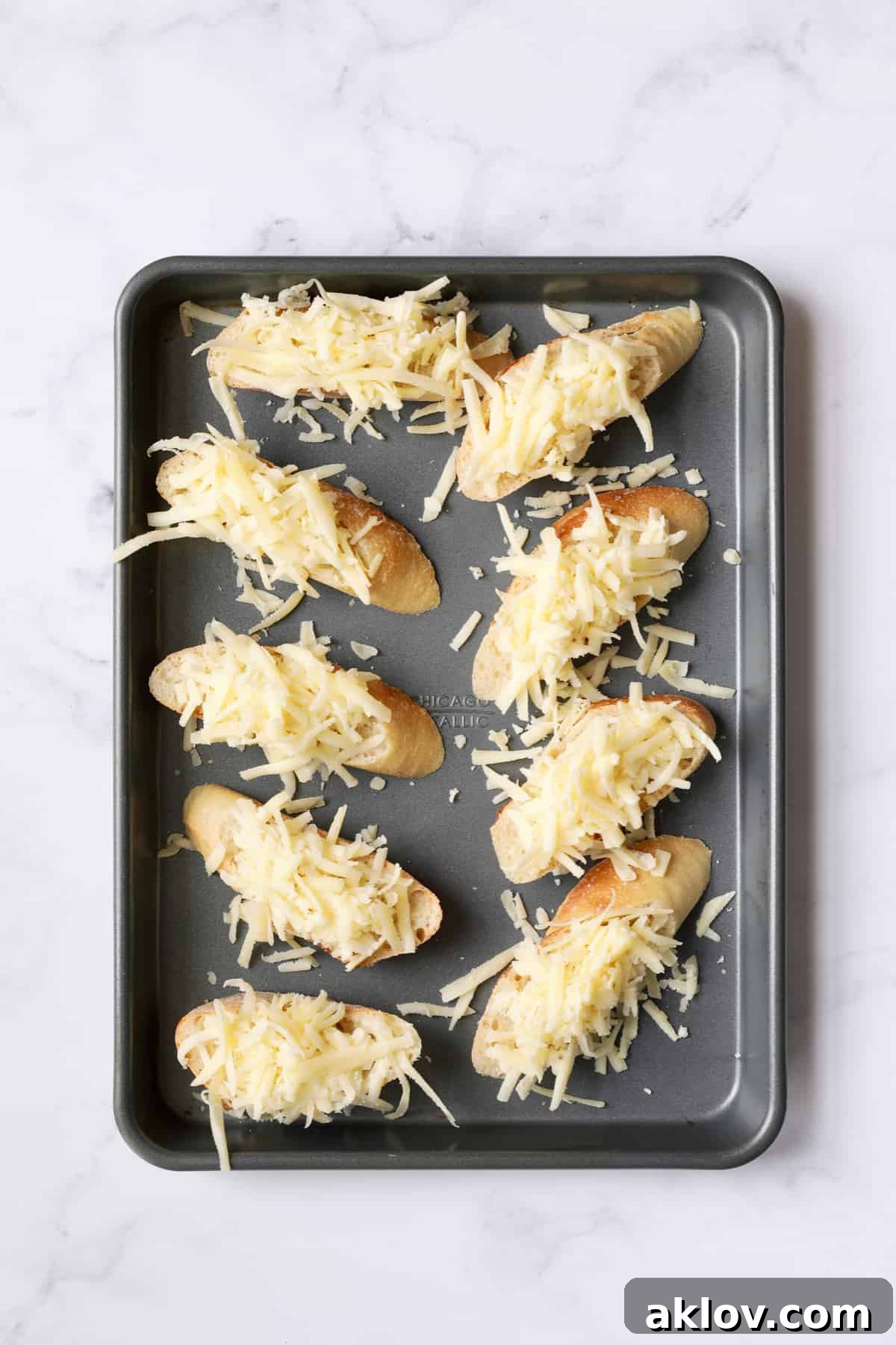 Date Night French Onion Indulgence 11 Photo of 9 slices of French bread with cheese on top before placing in the oven.
