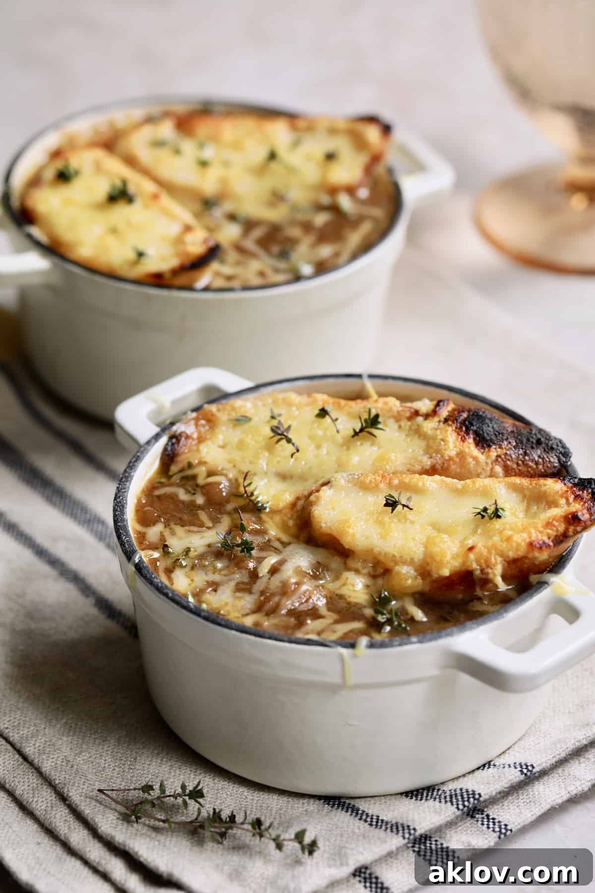 Date Night French Onion Indulgence 13 Photo of French Onion Soup for Two on black striped napkin garnished with the bread and thyme leaves.