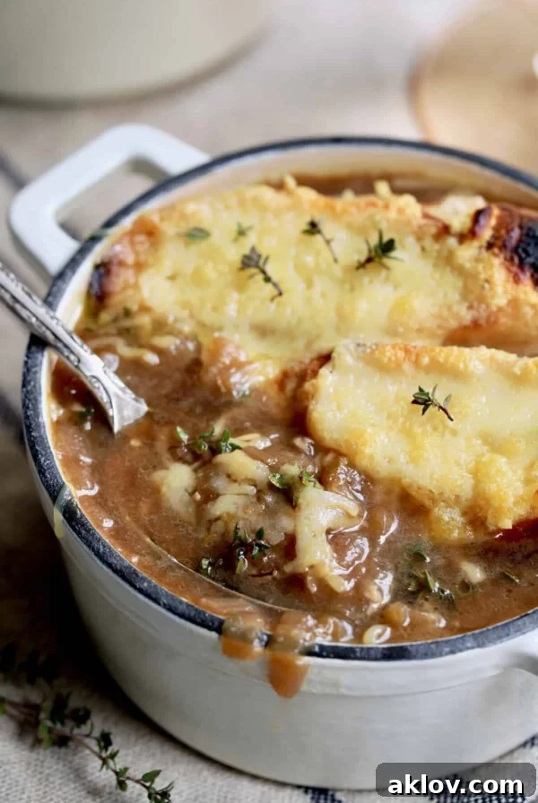 French Onion Soup for Two - Close-up shot with spoon lifting out some of the soup
