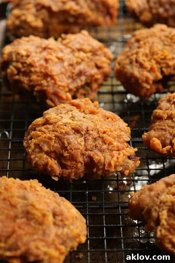 Close-up of golden brown, crispy fried chicken on a rack after frying, awaiting the iconic Nashville Hot Chicken sauce.