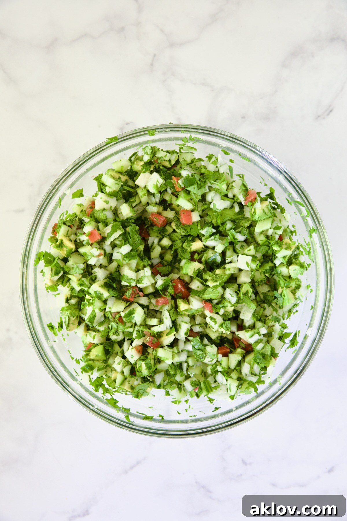 Vegetables in glass bowl after being stirred.