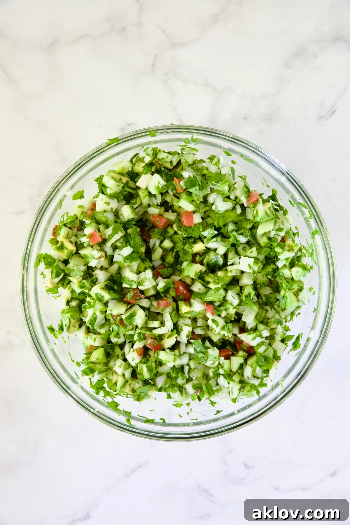 The vibrant mix of diced vegetables, gently stirred in a glass bowl.