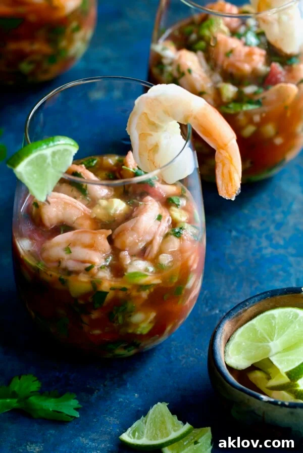 Mexican Shrimp Cocktail in glass garnished with lime wedge and shrimp.