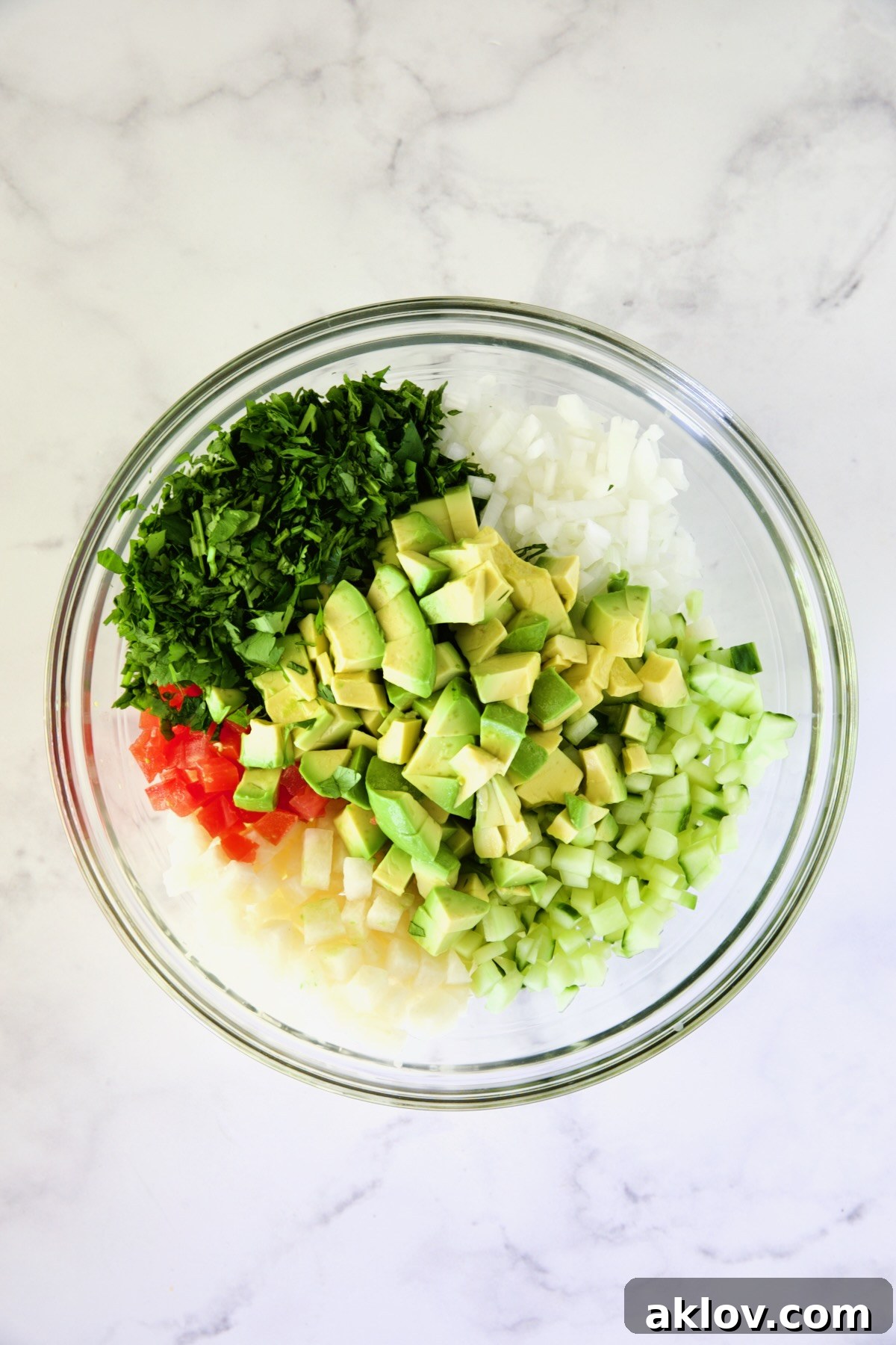 Vegetables in glass bowl for shrimp cocktail before being stirred.