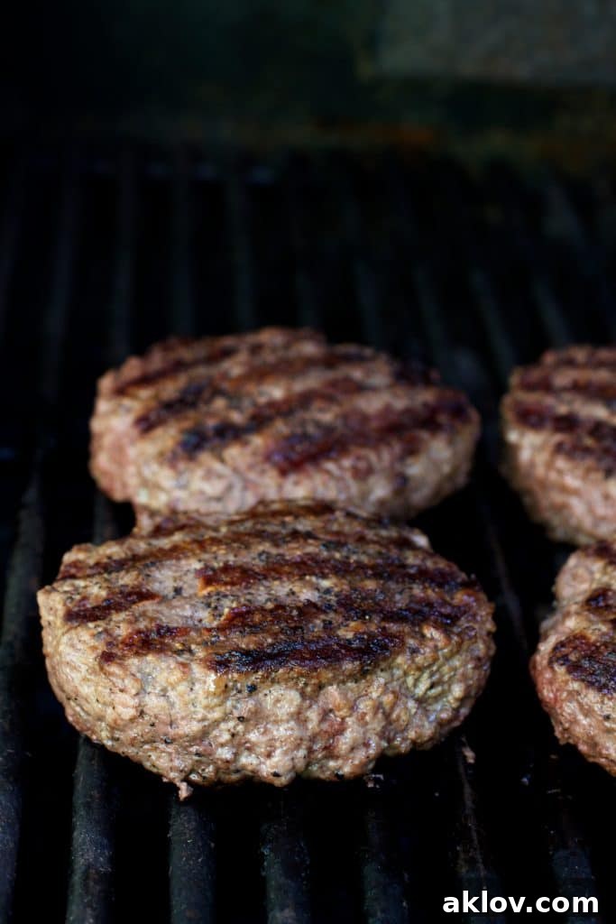 Photo of four grilled beef burgers.
