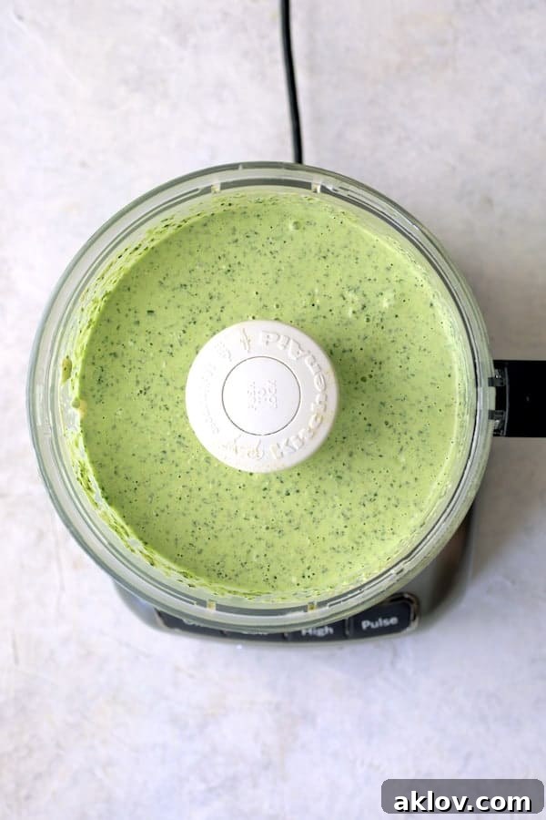 Photo of the vibrant green Spicy Pesto Aioli being prepared in a food processor, showcasing its creamy texture before serving.