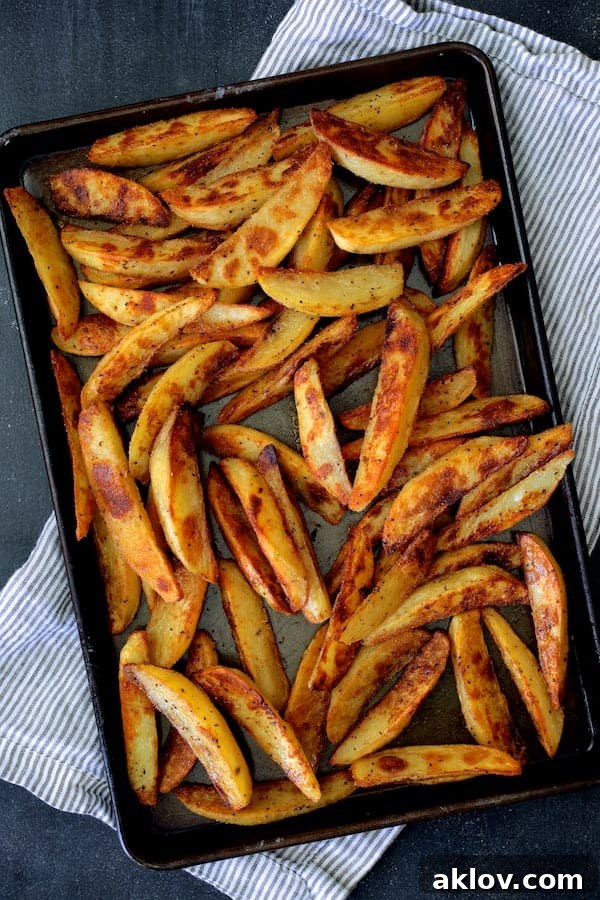 Photo of a baking sheet filled with perfectly cooked, golden-brown oven fries, crispy and ready to be served.
