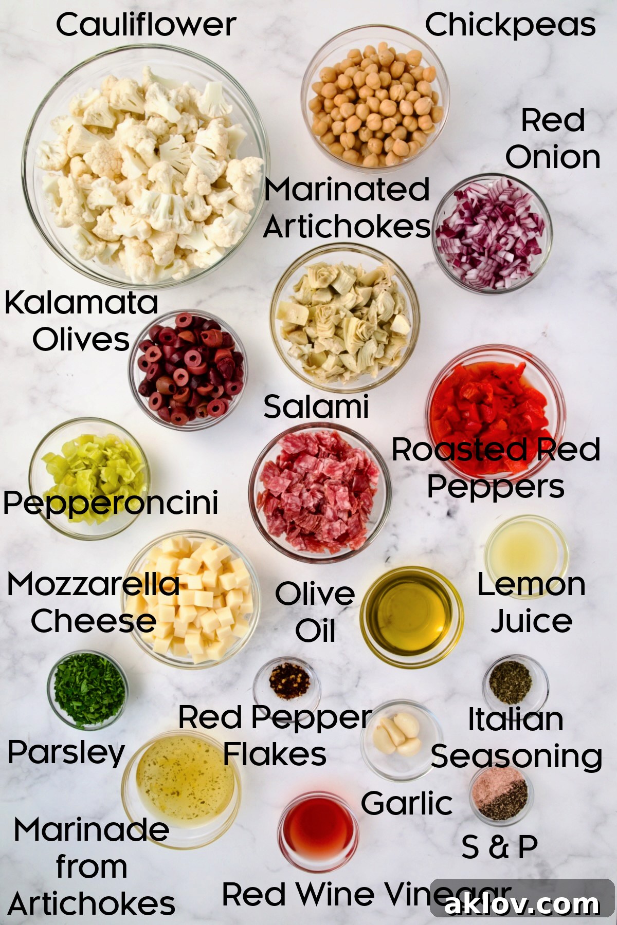A collection of fresh, colorful ingredients for Cauliflower Antipasto Salad displayed in clear glass bowls, highlighting their vibrant textures and readiness for assembly.