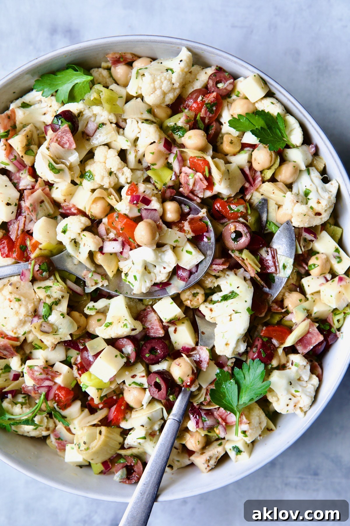 A close-up of the delicious Cauliflower Antipasto Salad in a stylish blue serving bowl, highlighting the colorful ingredients and tantalizing dressing, ready for enjoyment.