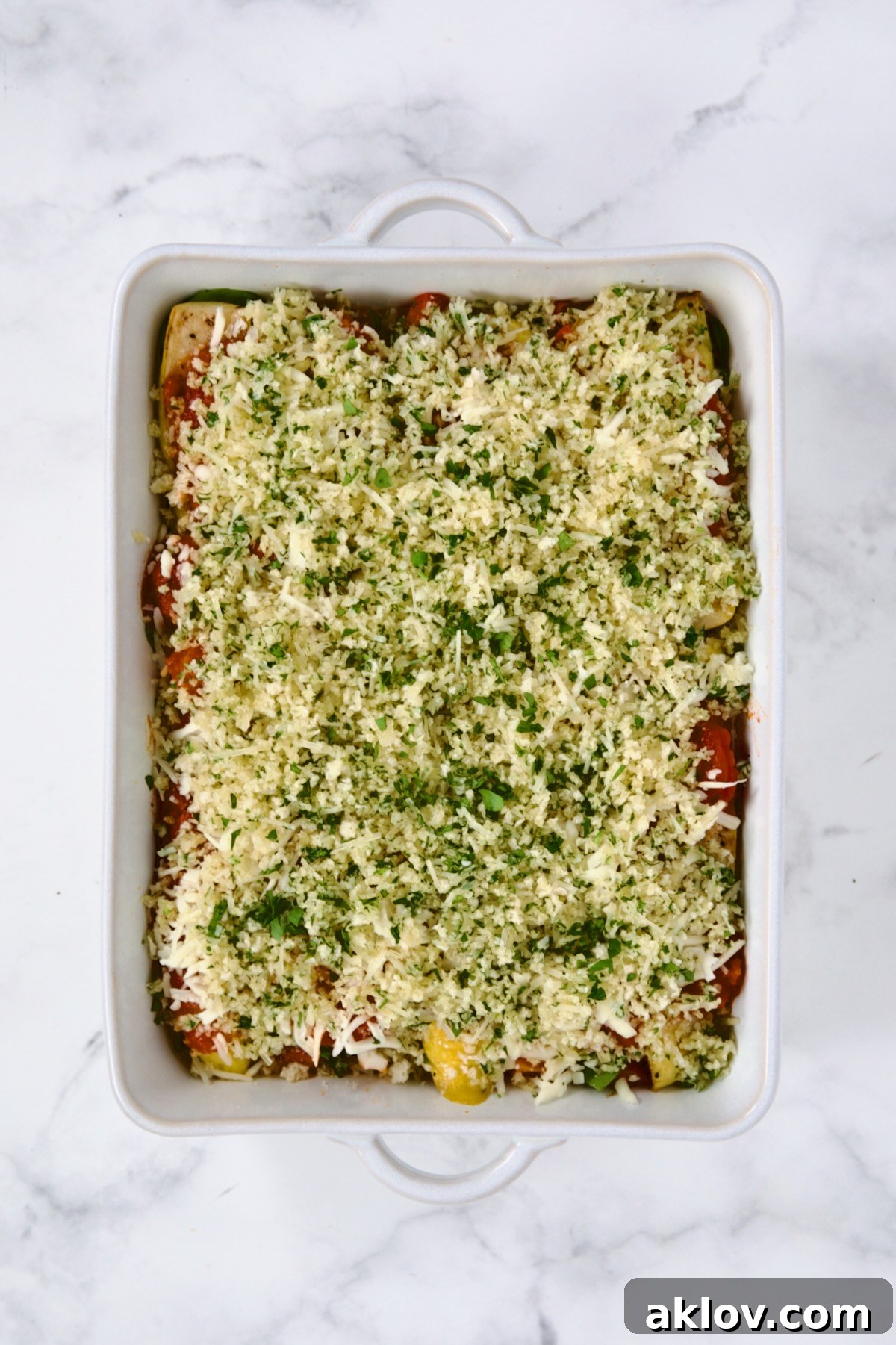 Fully assembled Summer Vegetable Parmigiana in white rectangular dish before being baked.