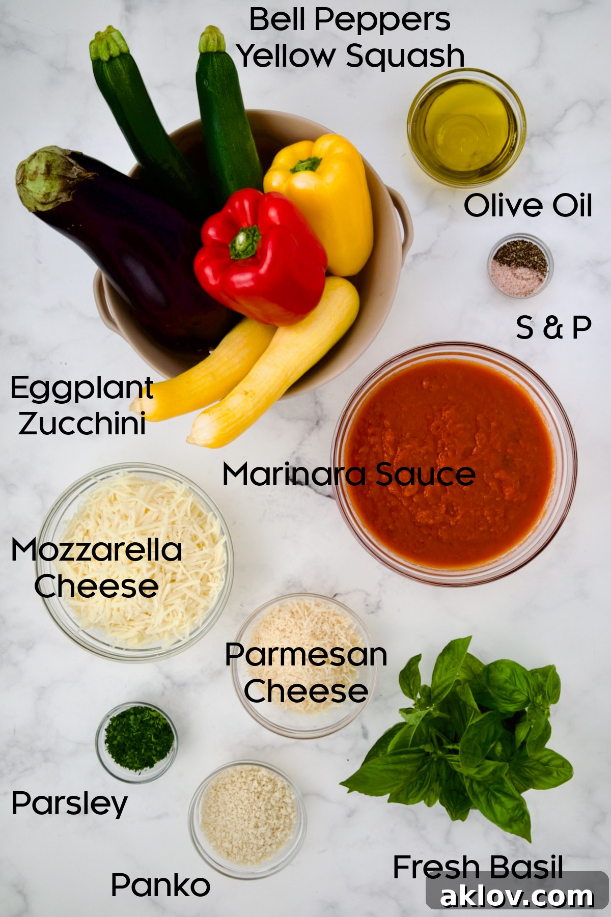 Assorted fresh ingredients for Summer Vegetable Parmigiana neatly arranged in glass bowls, including sliced eggplant, zucchini, yellow squash, bell peppers, marinara sauce, mozzarella, Parmesan, fresh basil, and panko breadcrumbs.