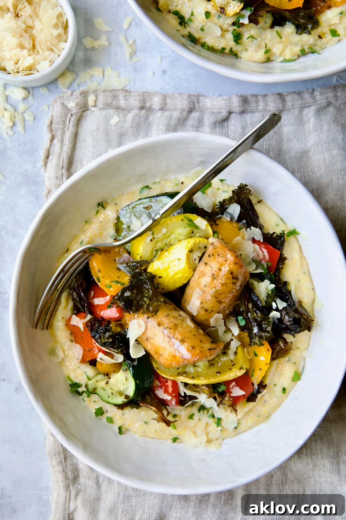 Chicken Sausage Sheet Pan and Polenta in white bowl with fork.