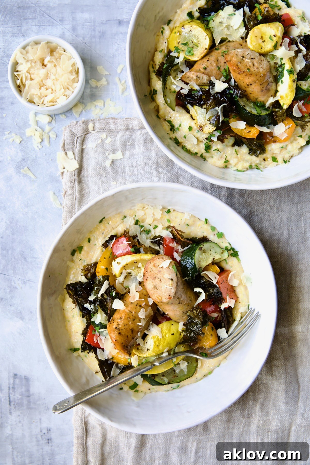 Two servings of Chicken Sausage Sheet Pan and Polenta in white bowls.