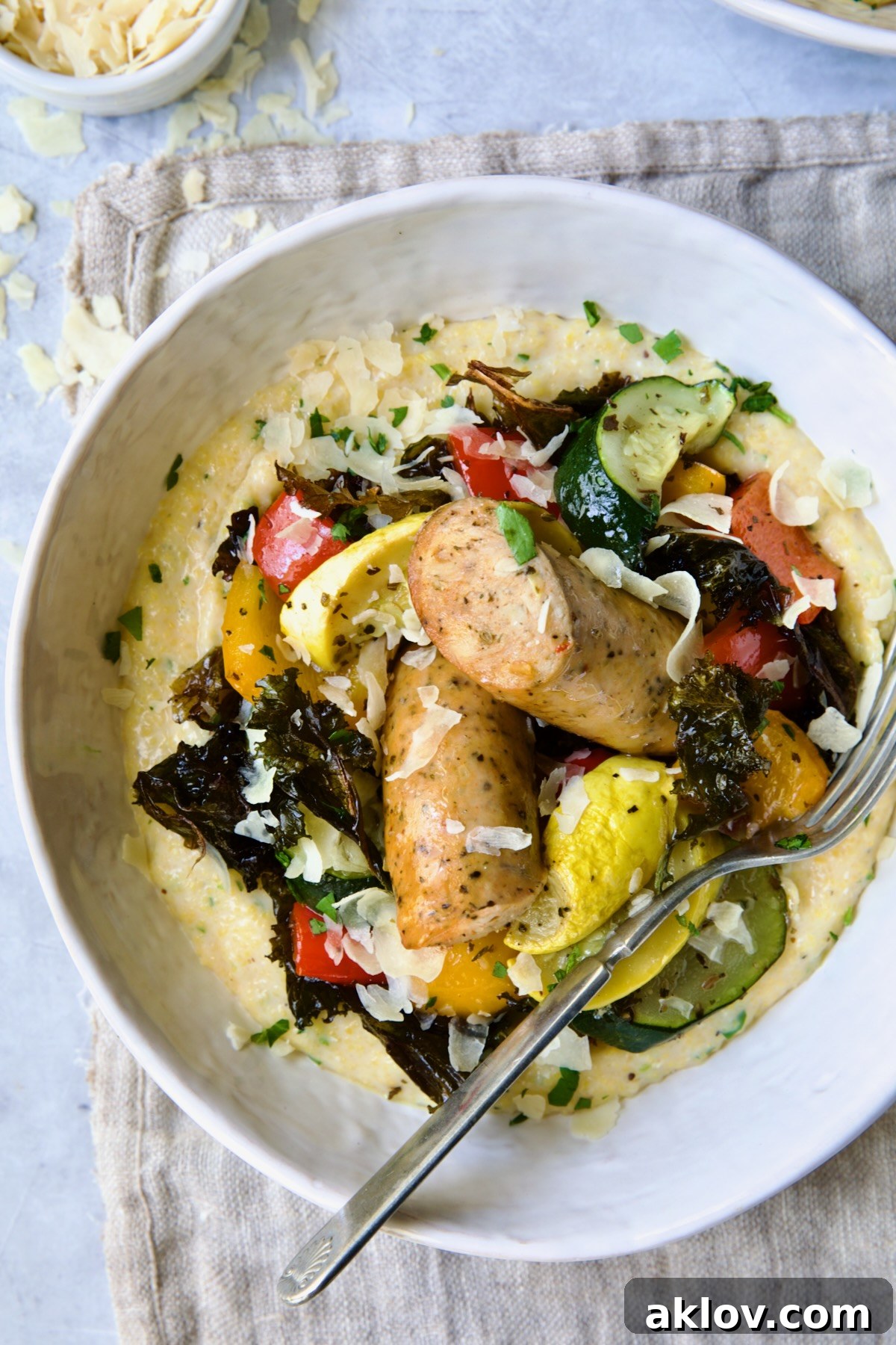 Chicken Sausage Sheet Pan and Polenta in white bowl with fork.