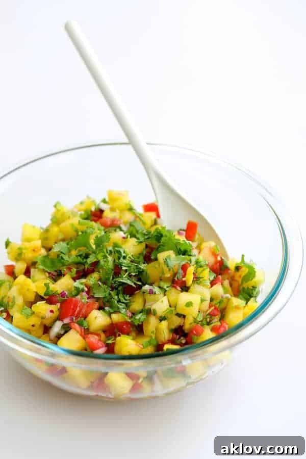 Close-up of fresh, vibrant Watermelon Tomato Salsa in a clear glass bowl, featuring diced watermelon, tomatoes, red onion, and cilantro.