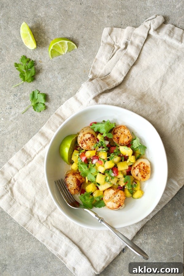 Overhead shot of perfectly Seared Sea Scallops artfully arranged in a white bowl, accompanied by a generous portion of colorful Watermelon Tomato Salsa.