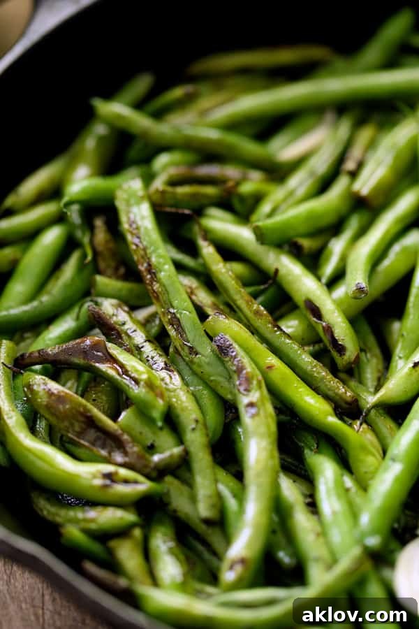 Close-up photo of Skillet Charred Green Beans with Goat Cheese Chipotle Butter in cast iron skillet.