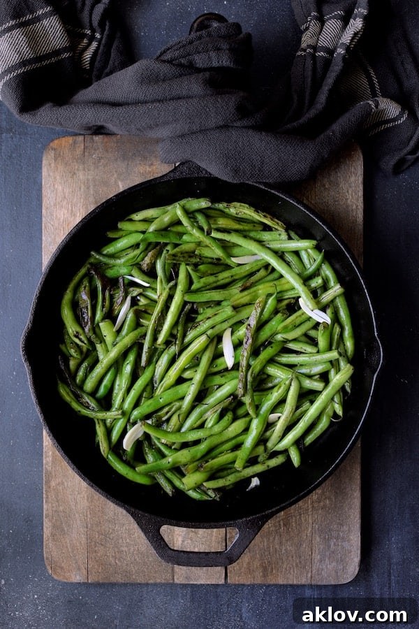 Skillet Charred Green Beans, perfectly blackened and crisp-tender, in a cast iron skillet before the butter is added.