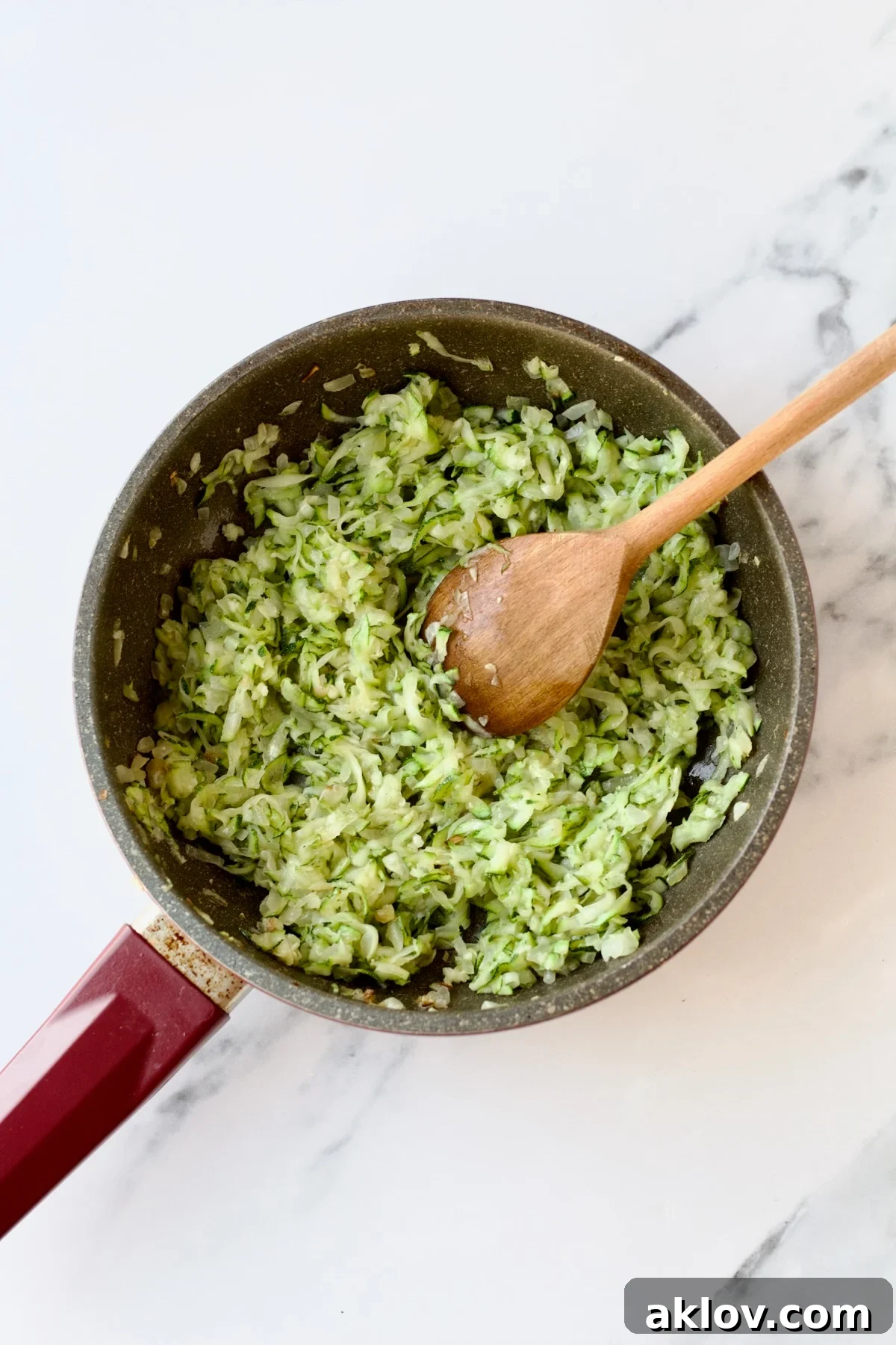 The perfectly sautéed mixture of zucchini, onions, and garlic rests in a nonstick skillet, ready for the next step in the recipe.