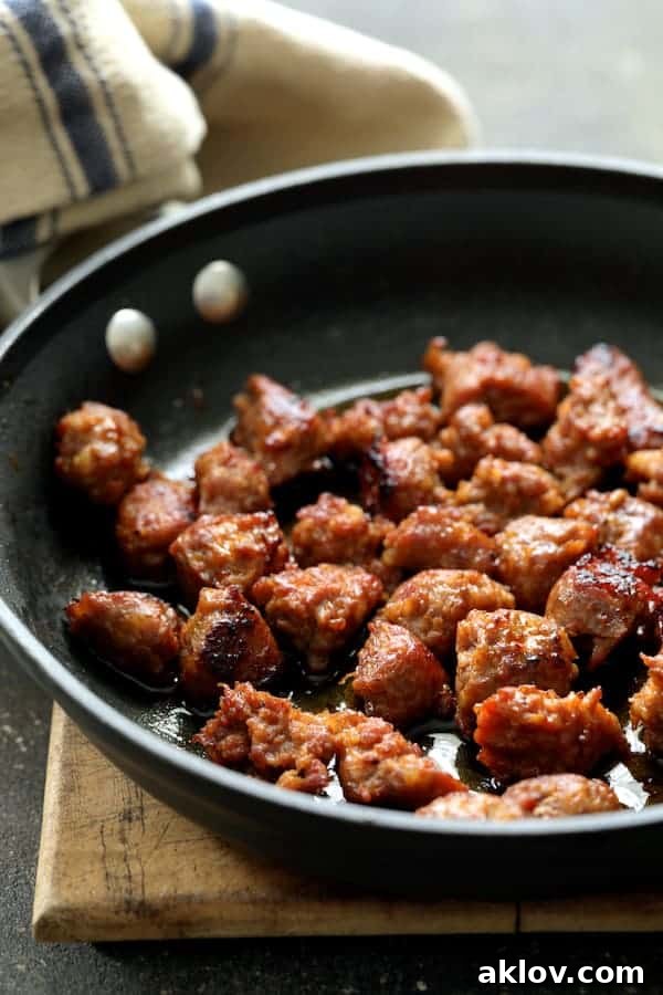 A photo of cooked and crumbled Italian sausage in a skillet, ready to be added to the polenta bake.