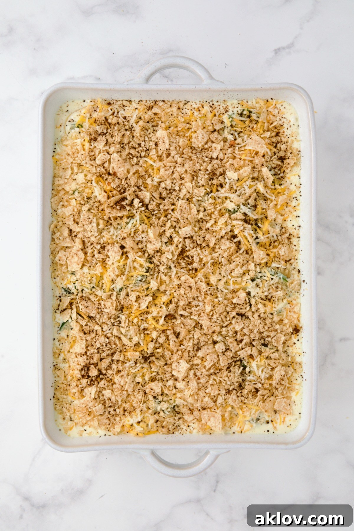 Summer Squash Corn Poblano Casserole prepared with a crispy tortilla chip topping and a dusting of chili powder.