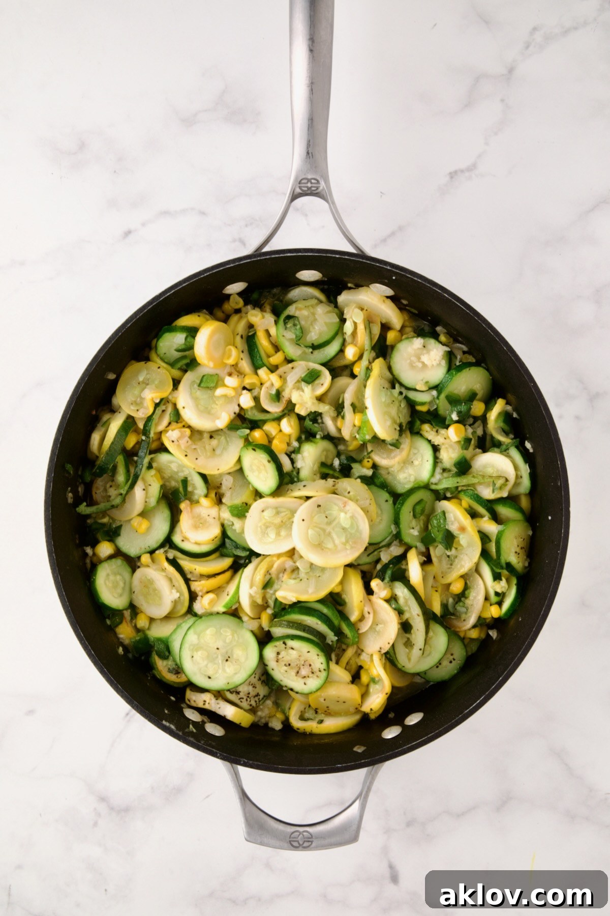 Cooked zucchini, yellow squash, poblano, and corn in a nonstick skillet, fragrant and ready for the baking dish.