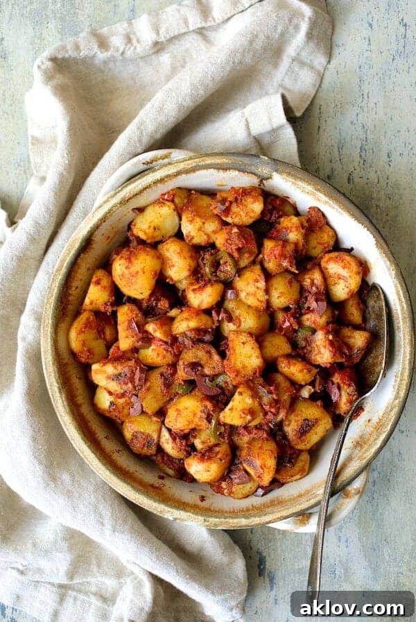 Chile Potatoes (Patatas Bravas Chilenas) in earthenware bowl with serving spoon.