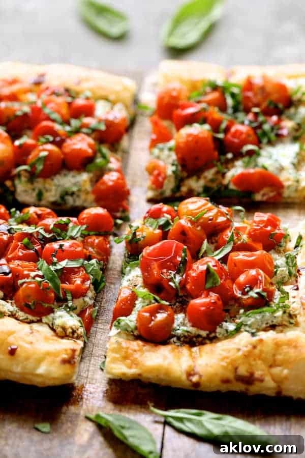 Close-up photo of a Roasted Cherry Tomato Tart with Herbed Ricotta, showing the intricate layers and vibrant colors of the tomatoes and herbs.