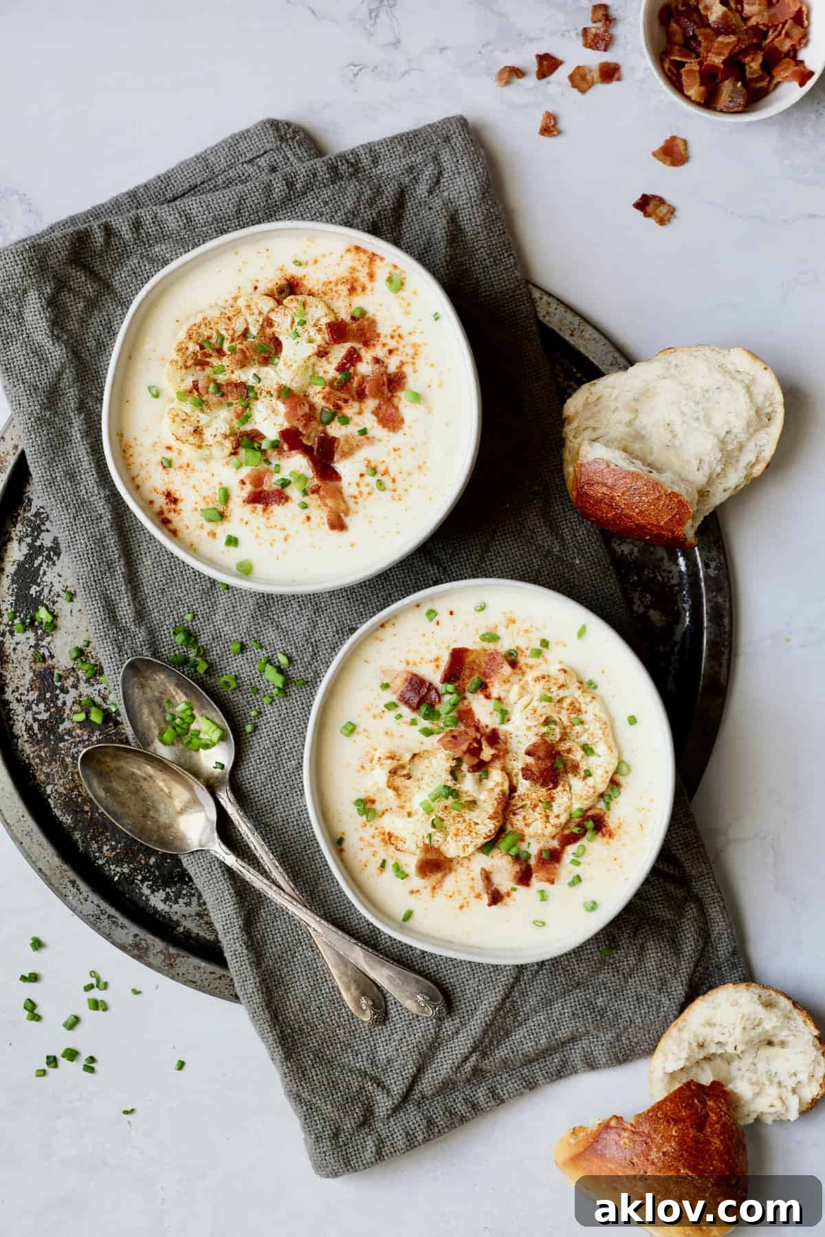 Cauliflower Potato Soup with Smoked Gouda beautifully garnished with roasted cauliflower florets, crispy bacon, and fresh chives, ready to be enjoyed.
