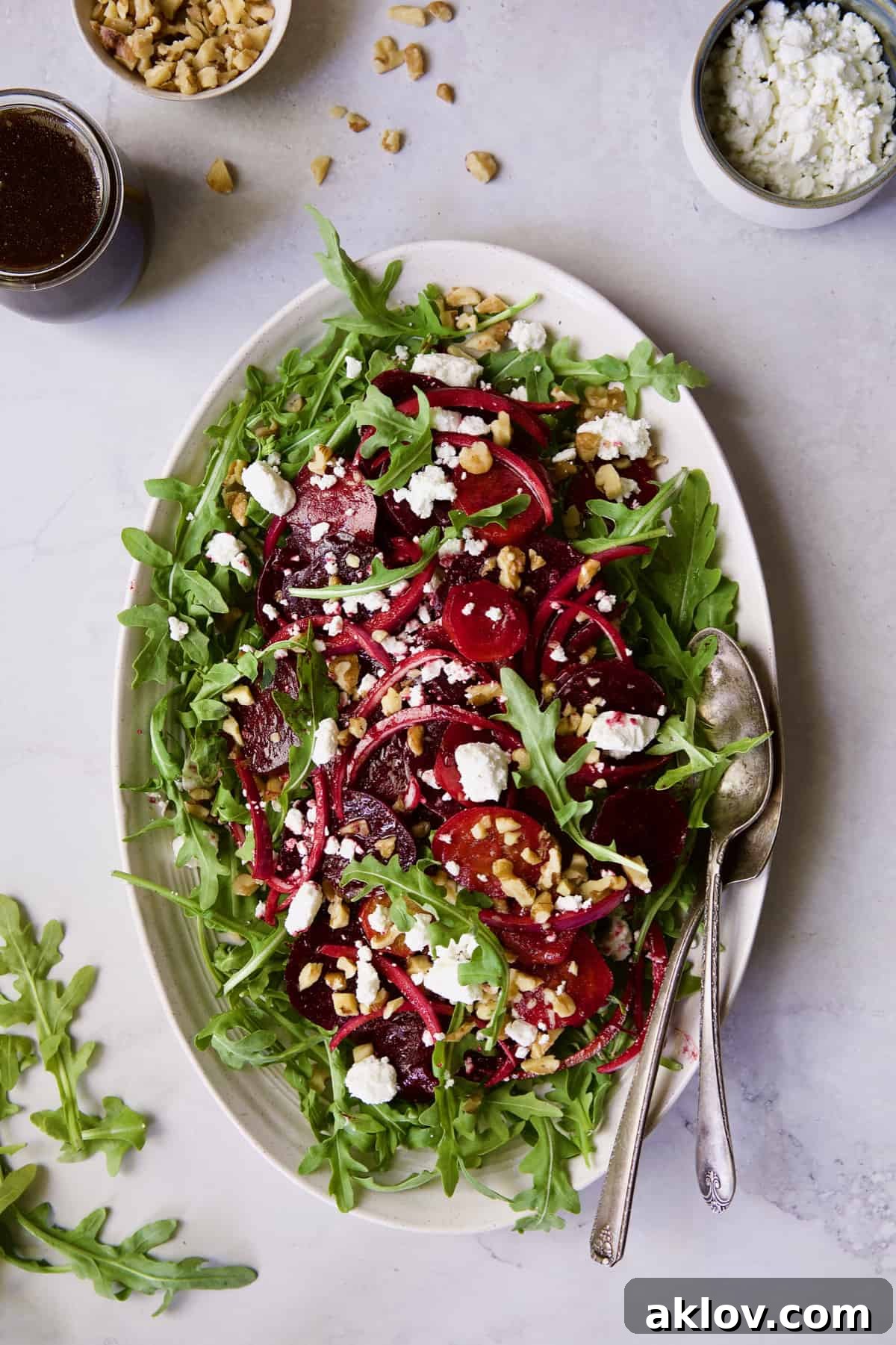 Roasted Beet Salad with Walnuts Goat Cheese and Honey Balsamic Dressing with dressing, walnuts and goat cheese in small bowls.