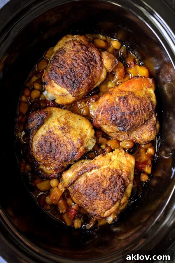 Aromatic Moroccan Chicken Tagine 4 A top-down view of the Moroccan Chicken Tagine after slow cooking, featuring tender chicken, softened butternut squash, chickpeas, and olives, simmering in a rich, aromatic sauce.