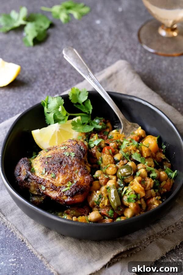 Authentic Moroccan Chicken Tagine 6 A single serving of Moroccan Chicken Tagine with Butternut Squash, Chickpeas, and Olives presented in an elegant black bowl.