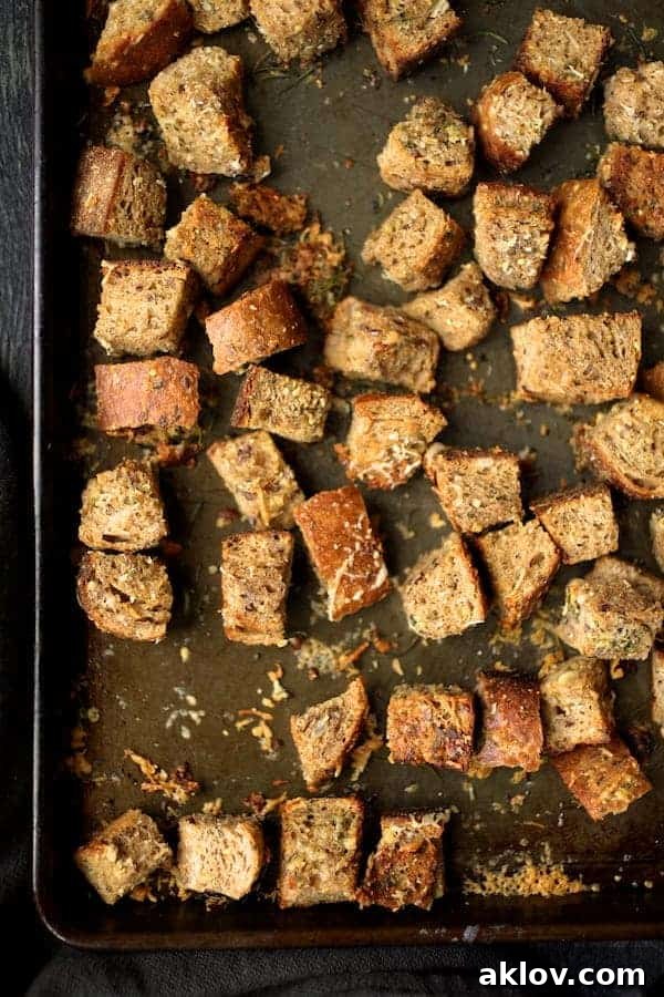 Crispy Whole-Grain Thyme, Rosemary, and Parmesan Croutons on a baking sheet, ready to be enjoyed.