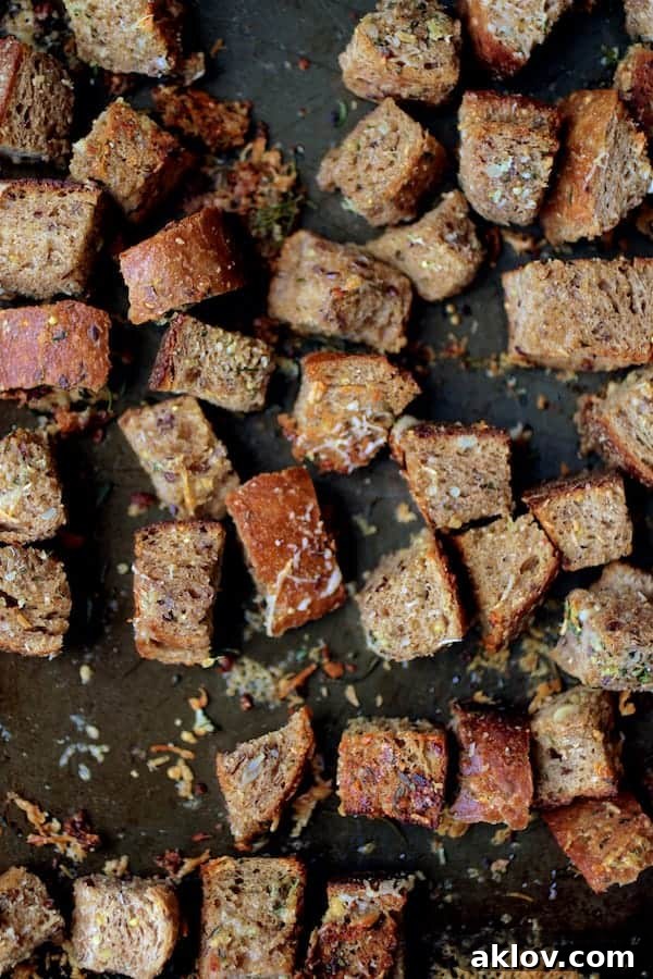 Close-up of perfectly golden and crispy Whole-Grain Thyme, Rosemary, and Parmesan Croutons.