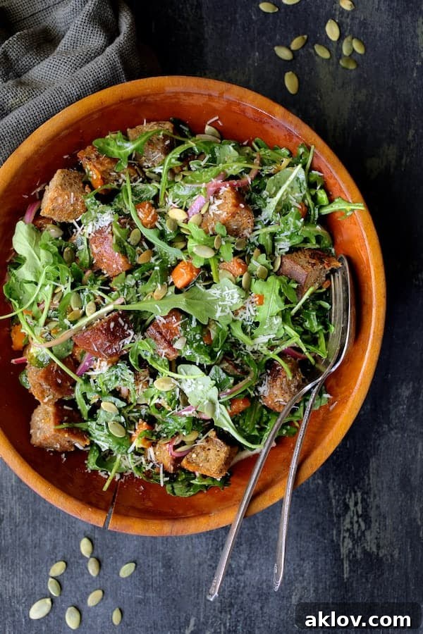 Autumn Panzanella Salad presented in a wooden bowl with serving utensils, ready for guests.