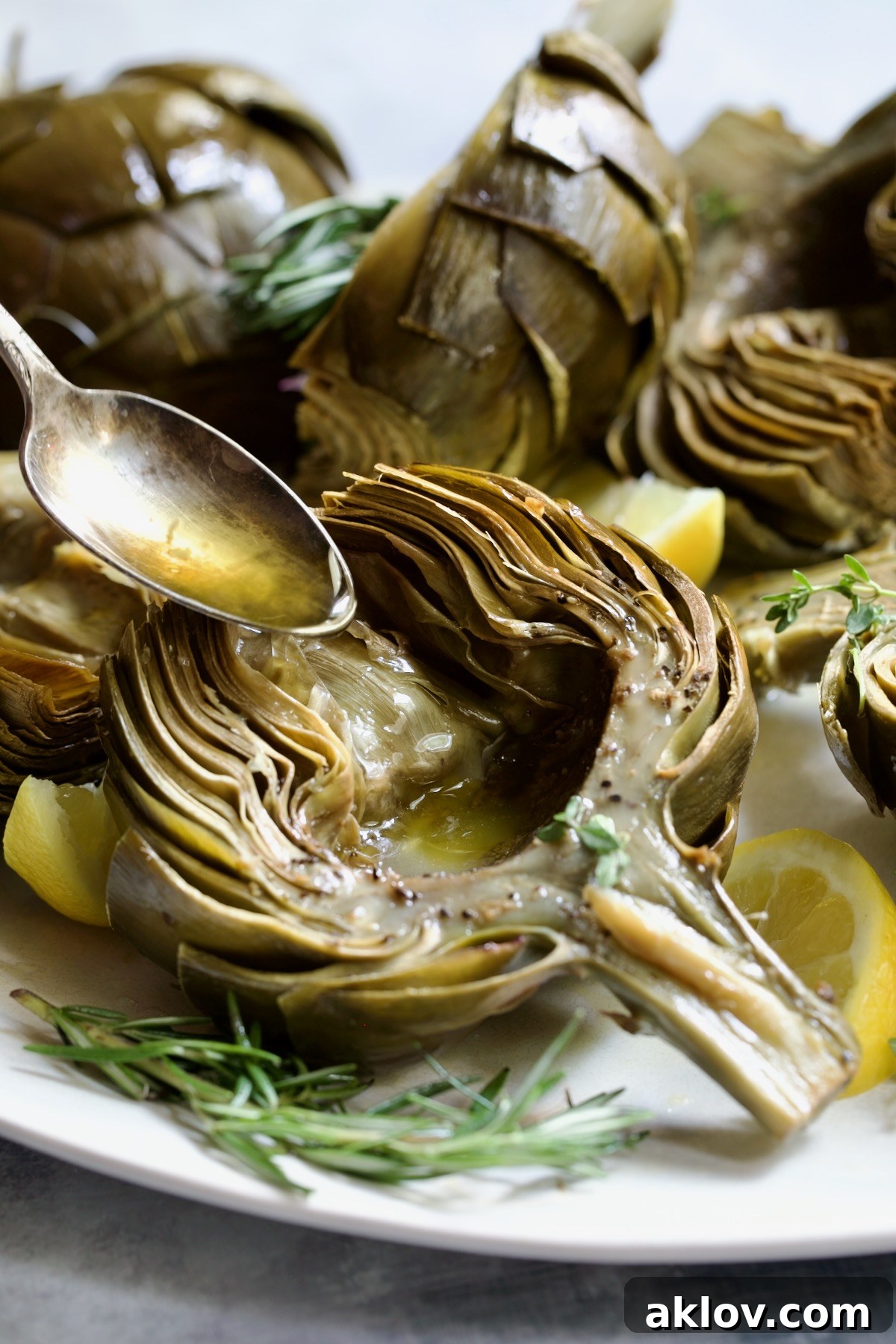 Buttery Garlic Roasted Artichokes 3 Butter being poured into the well of a roasted artichoke half.