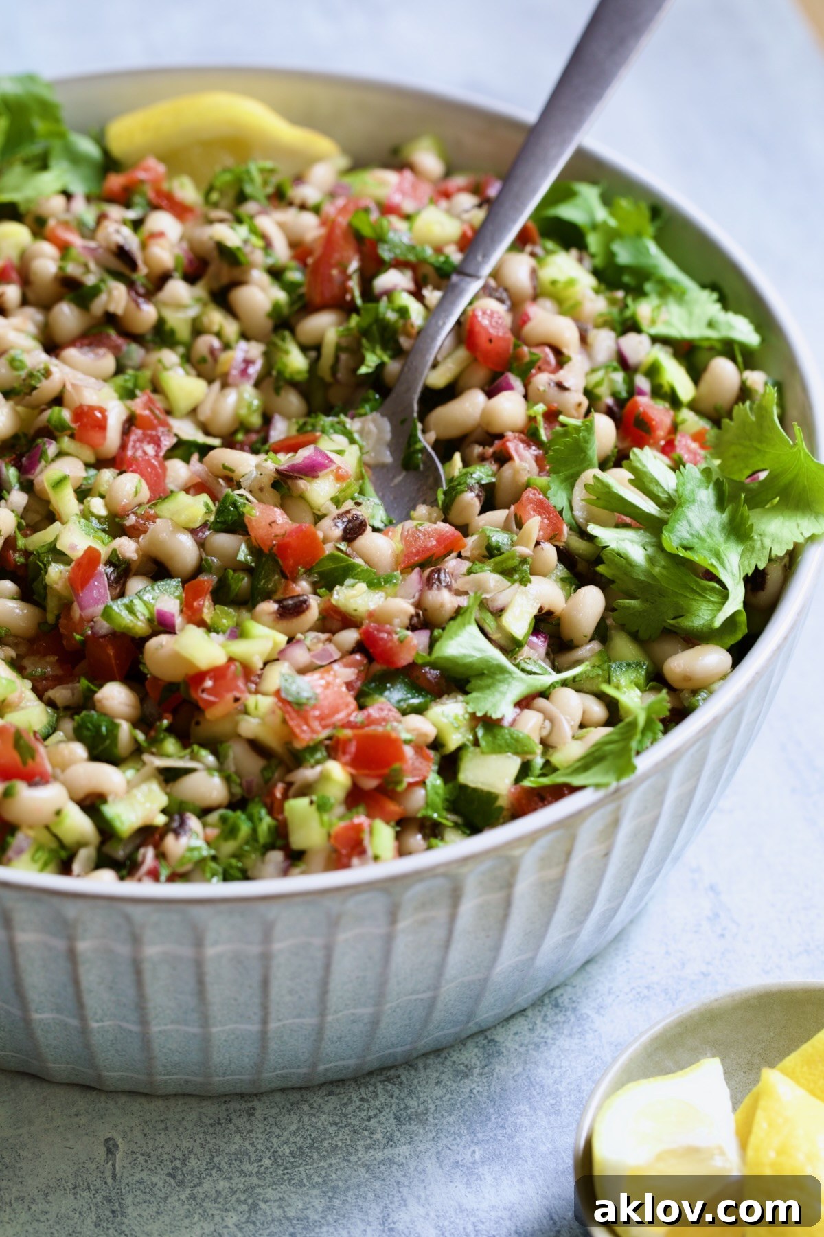 Black-Eyed Pea Salad presented in an elegant serving bowl, accompanied by a serving spoon, inviting you to indulge in its fresh flavors.