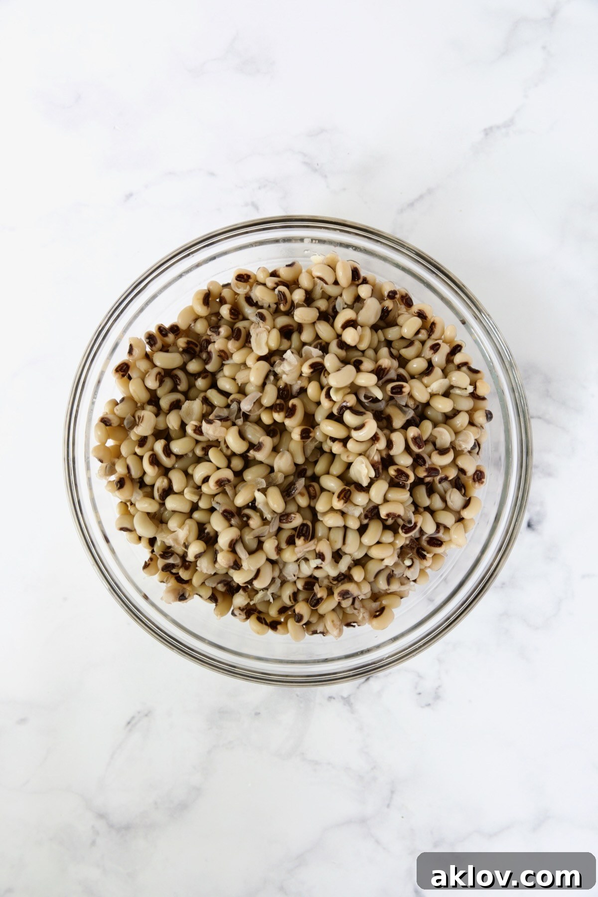 Perfectly cooked black-eyed peas resting in a clear glass bowl, showcasing their tender texture, ready to be incorporated into the salad.